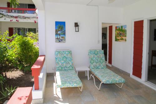 two chairs and a table on a porch at Antigua Village Beach Resort in Saint Johnʼs