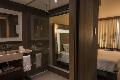 ein Bad mit einer Dusche, einem Waschbecken und einem Spiegel in der Unterkunft Novotel RJ Praia de Botafogo in Rio de Janeiro