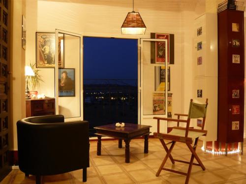 a living room with a table and a chair and a window at Casa Blues in Arcos de la Frontera