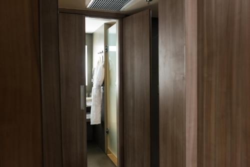 a hallway with a door to a bathroom with a mirror at Novotel RJ Praia de Botafogo in Rio de Janeiro
