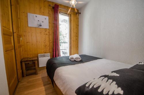 um quarto com uma cama e uma janela num quarto em Litchi Apartment em Chamonix-Mont-Blanc