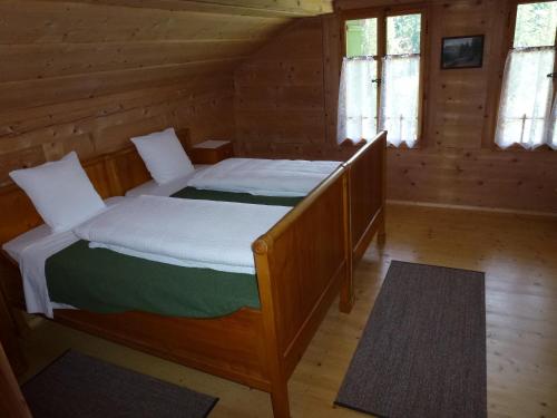 a bedroom with a bed in a log cabin at Hotel Waldrand in Kiental
