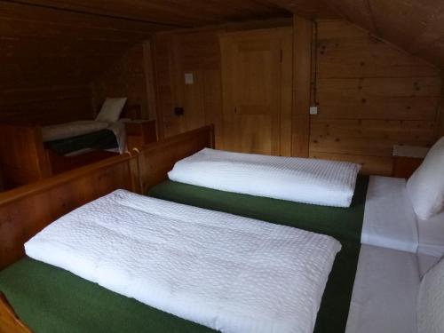 two beds in a boat with white sheets at Hotel Waldrand in Kiental
