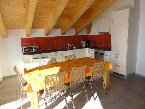 Una cocina con una mesa y sillas de madera. en Apartment Amore, en Riederalp