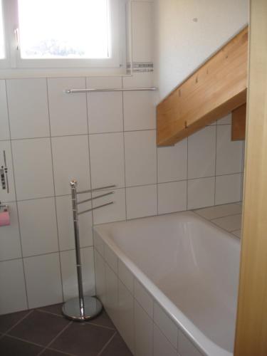 Un baño blanco con bañera y ventana. en Apartment Amore, en Riederalp
