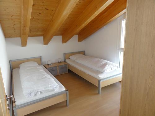 une chambre avec deux lits et une fenêtre dans l'établissement Apartment Amore, à Riederalp