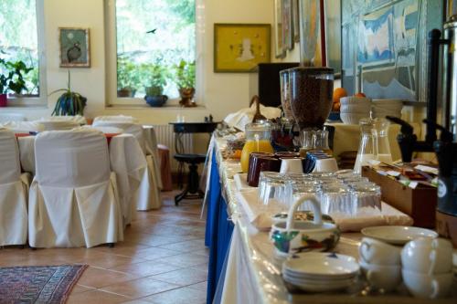 ein Zimmer mit einem Tisch mit Tellern und Geschirr darauf in der Unterkunft Albergo Giardino in Balatongyörök