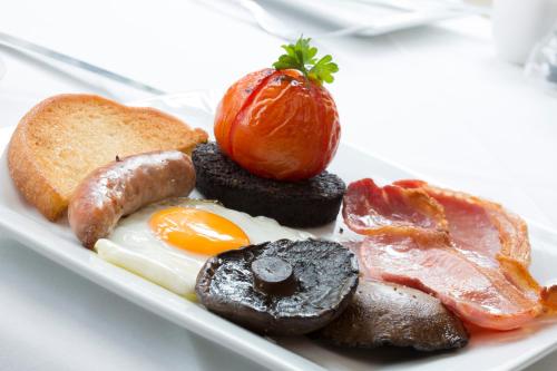 a plate of breakfast food with eggs sausage and toast at Hazel Bank Country House Borrowdale Valley in Rosthwaite