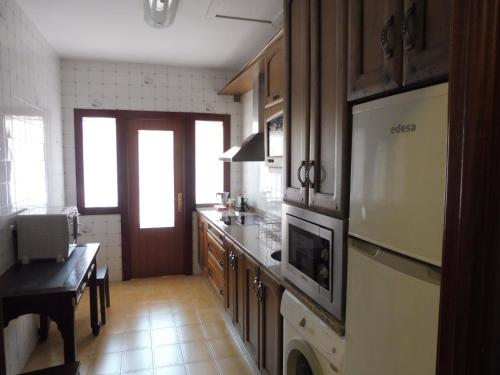 a kitchen with a refrigerator and a stove top oven at VillaDolores in La Alberca