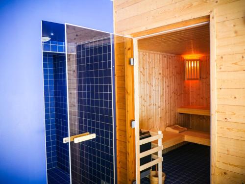 un sauna avec une porte en verre et une douche dans l'établissement Village Vacances Passion L'Estibère, à Vielle-Aure