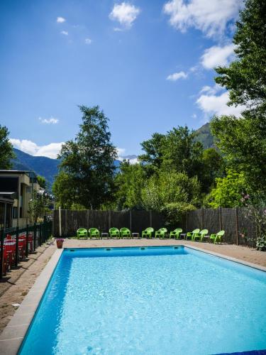 une piscine avec des chaises et une clôture dans l'établissement Village Vacances Passion L'Estibère, à Vielle-Aure