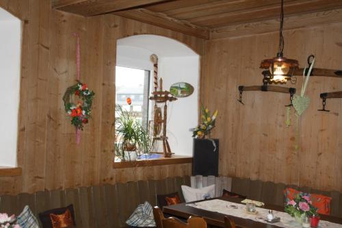 ミュンヒベルクにあるPension Fuchsbauのウッドウォールとテーブル、窓のあるダイニングルーム