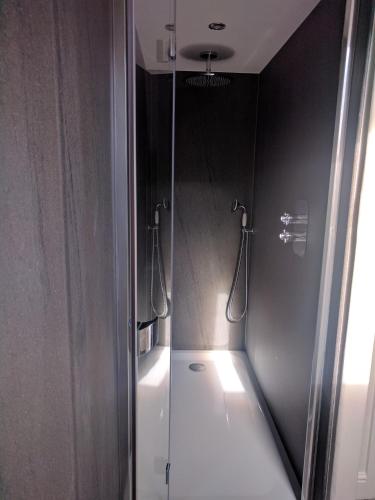 a bathroom with a shower with a mirror at Avenue House in Bakewell