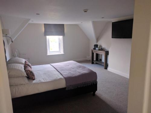 a bedroom with a bed and a window at Avenue House in Bakewell