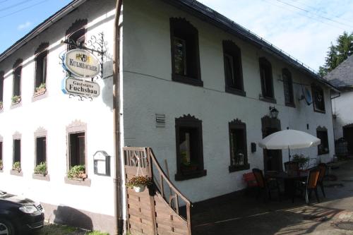 a white building with a table in front of it at Pension Fuchsbau in Münchberg