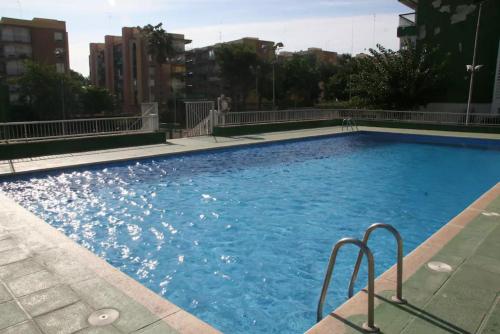 a large swimming pool with blue water in a city at Marenostrum view in Playa Pobla de Farnals