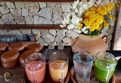 a table with drinks and a vase with flowers at Hotel Escondido, Puerto Escondido, a Member of Design Hotels - Adults Only in Puerto Escondido