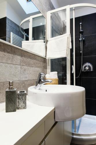 a bathroom with a sink and a toilet and a mirror at Lora Luxury House, near the lake with air conditioners in Como