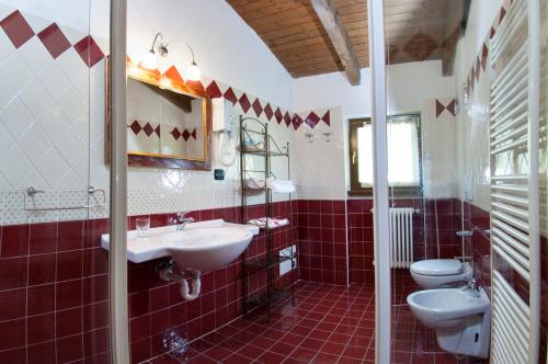 a bathroom with two sinks and two toilets at Trattoria Del Bivio in Cerretto Langhe
