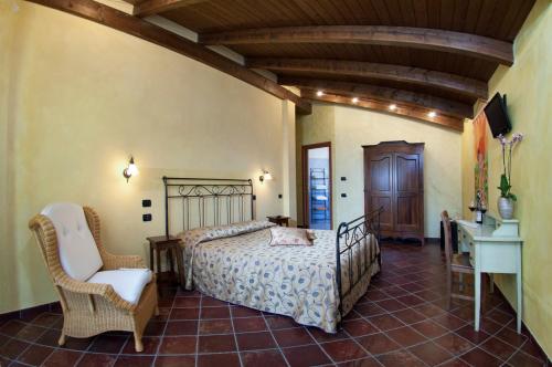 a bedroom with a bed and a chair and a desk at Trattoria Del Bivio in Cerretto Langhe