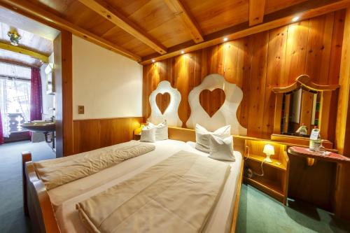 a bedroom with a bed with a wooden wall at Hotel & Gasthof Fraundorfer in Garmisch-Partenkirchen