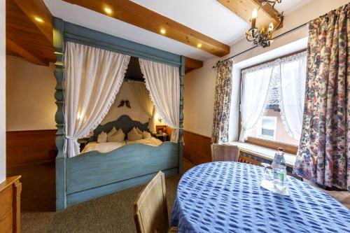 a bedroom with a bed with a blue canopy at Hotel & Gasthof Fraundorfer in Garmisch-Partenkirchen