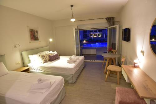 a hotel room with two beds and a window at Issalos Studios in Skala Potamias
