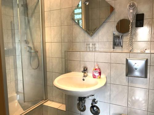 a bathroom with a sink and a shower at Hotel Restaurant Alt Laubach in Laubach