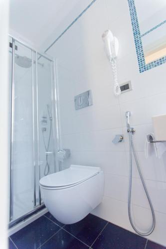 a white bathroom with a shower and a toilet at Hotel Piacenza in Milan