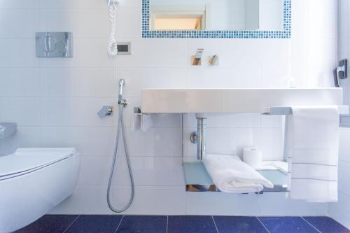 bagno bianco con lavandino e servizi igienici di Hotel Piacenza a Milano