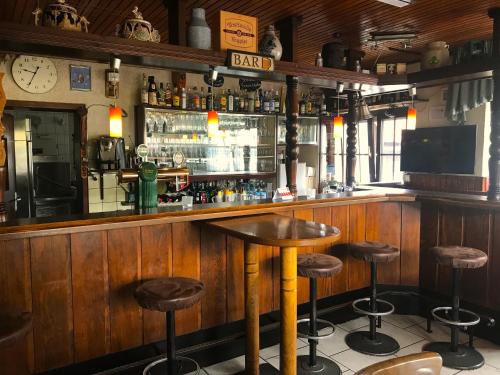 um bar com um balcão de madeira e bancos de bar em Hotel Restaurant Alt Laubach em Laubach