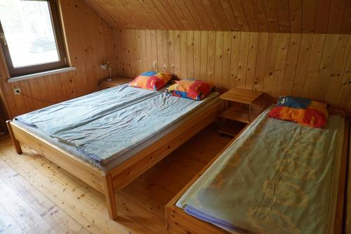 a bedroom with two beds in a wooden cabin at Vecmuižas in Roja