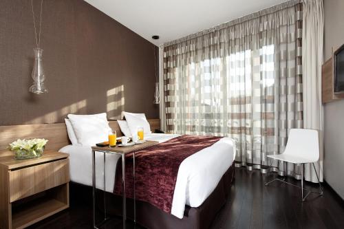 a bedroom with a large bed and a window at Citiz Hotel in Toulouse