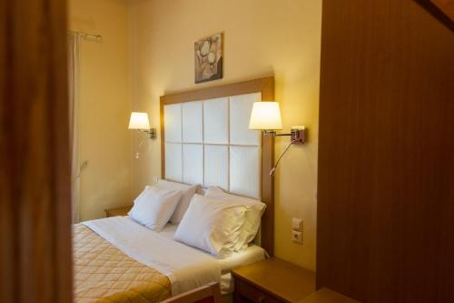 a bedroom with a bed with white sheets and pillows at Petros Penthouse in Parga
