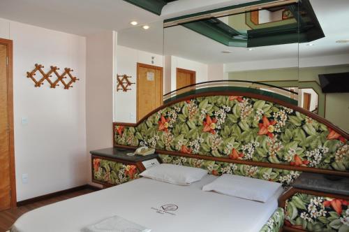 a bedroom with a bed with a floral head board at Hotel Barão do Flamengo (Adult Only) in Rio de Janeiro