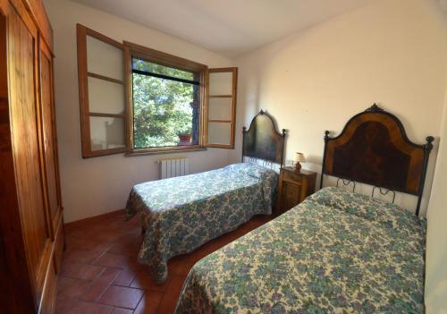 a bedroom with two beds and a window at La Sassetta in Bibbona