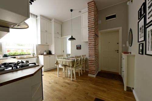 a kitchen with white cabinets and a table with chairs at Like at Home in Sopot