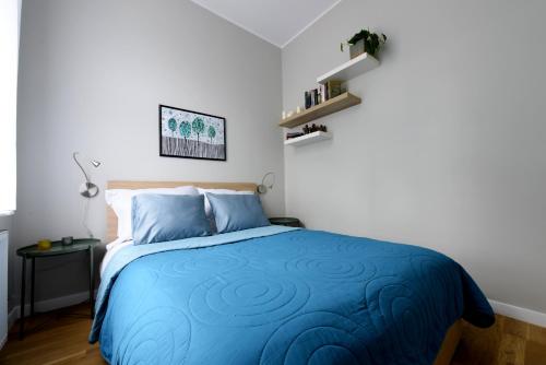 a bedroom with a bed with a blue comforter at Like at Home in Sopot
