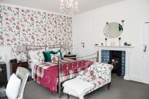 a bedroom with a bed and floral wallpaper at Jessop House in Tewkesbury
