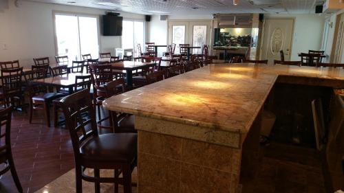a bar in a restaurant with tables and chairs at The Amethyst Beach Motel in Point Pleasant Beach