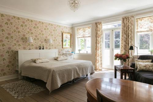a bedroom with a bed and a table and windows at Tiendegaarden Møns Klint in Borre