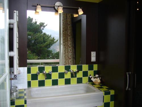 a bathroom with a sink and a window and a tub at Hotel Rural Casa Roja in Cadavedo