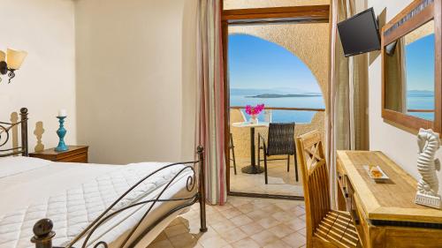 a bedroom with a bed and a view of the ocean at Hotel Abatis in Skala