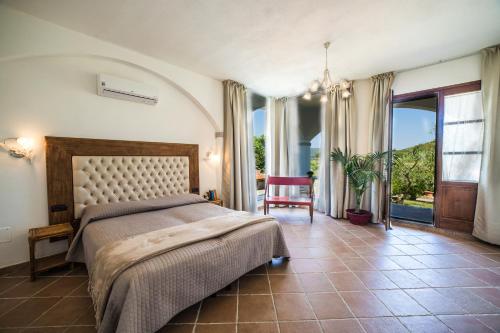 a bedroom with a bed and a large window at Villa il Poderino in Marina di Campo