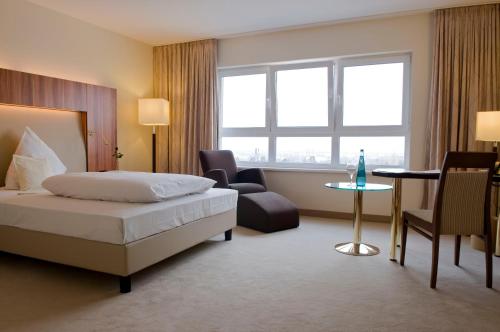 a hotel room with a bed and a chair and a table at Ringhotel Katharinen Hof in Unna