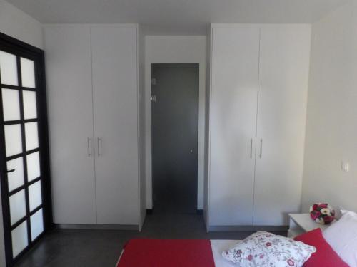 a bedroom with white cabinets and a red rug at Apothiki House in Kato Korakiana