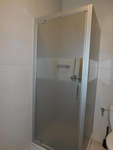a glass shower in a bathroom with a toilet at Apartament Pogodny in Łeba