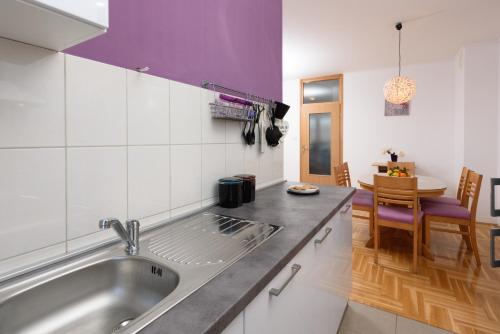 a kitchen with a stainless steel sink and a table at Dani in Trogir