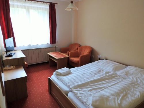 A bed or beds in a room at Penzion Montana