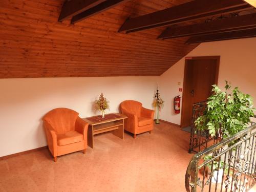 two orange chairs and a table in a room at Penzion Montana in Terchová